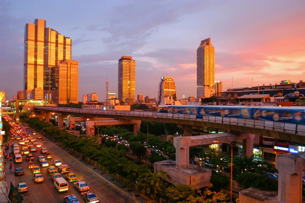 The BTS Skytrain curving past Bangkok towers at sunset